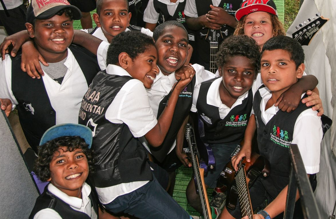 Image of a group of students carrying instruments to play music they learned as part of the Australian curriculum