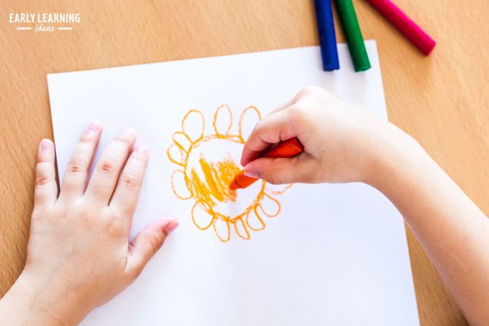 A young child using  Digital pronate grip to draw a flower. 
