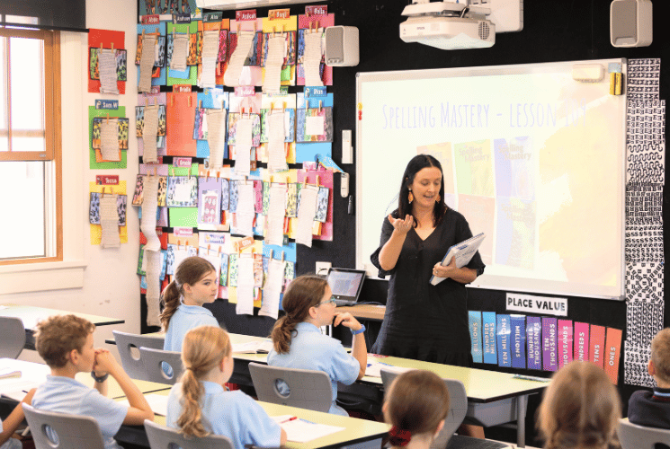 teacher in front of the classroom showing the class rules