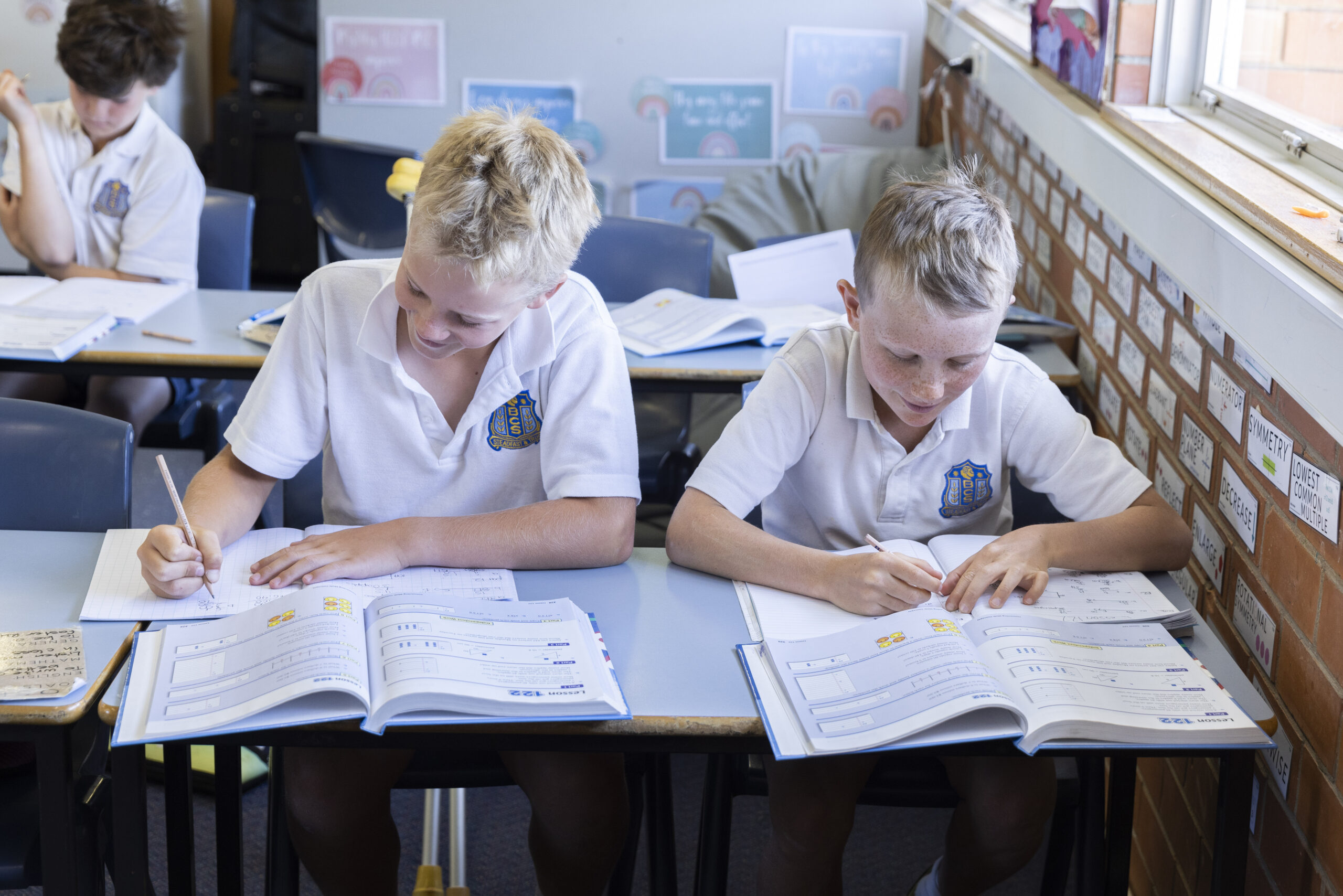 Teacher smiling with two students.